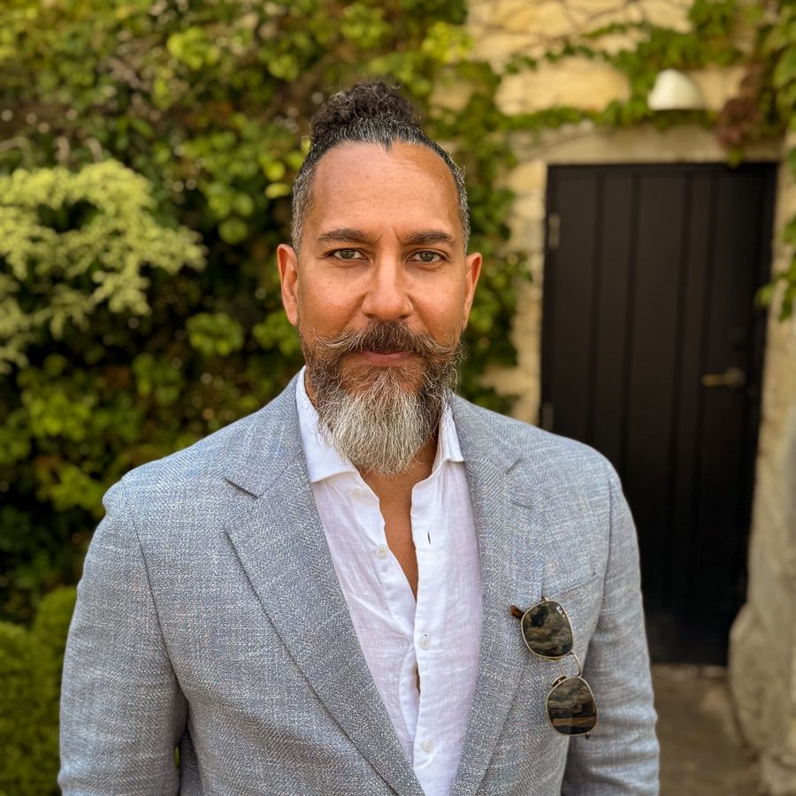 Dwayne Maginley, host of Echoed From Eden, standing outdoors in a grey blazer